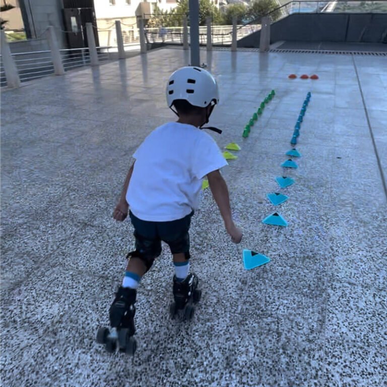 Kid with skates rolls inbetween two line of cones