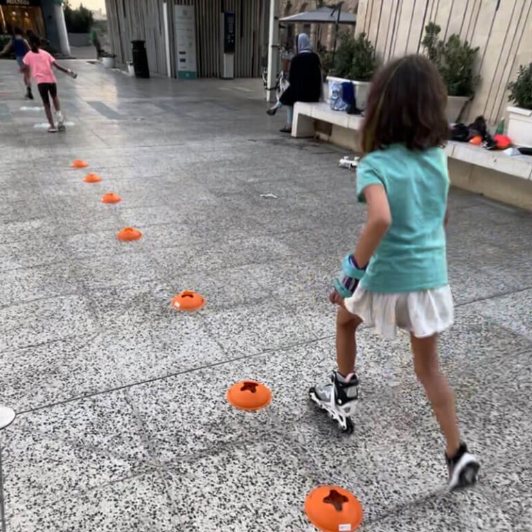 Kid with sneakers runs along cones